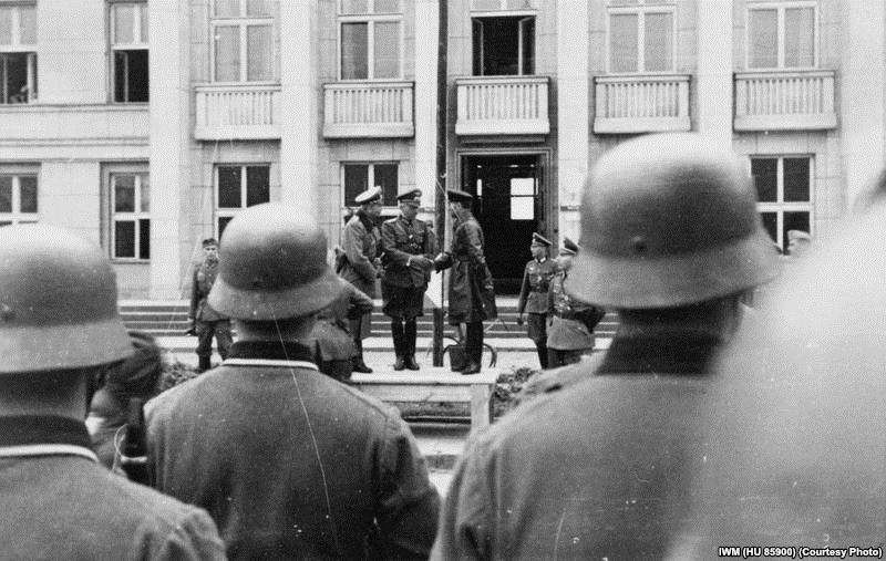 Немецкий подполковник Густав-Адольф Рибель жмет руку советскому комбригу Семену Кривошеину во время совместного нацистско-советского парада в Бресте.